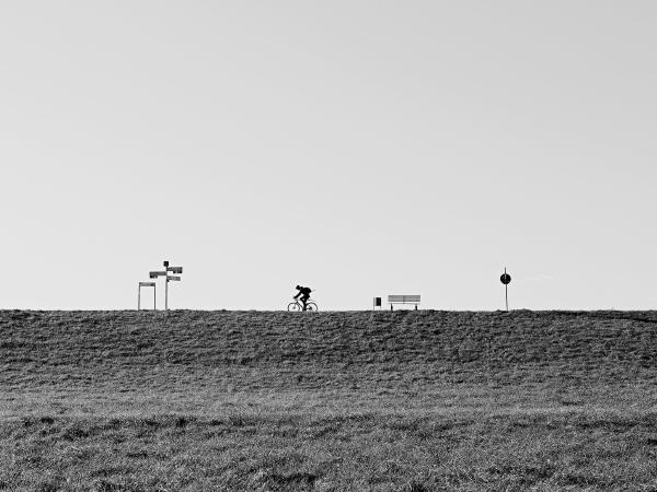 Week 43 - On the dike. The well-maintained path on the top of the dike is popular not only with walkers, but especially with cyclists. The signs on the left are signposts with distances to the surrounding places. There is a bench with a waste basket for a rest break.
